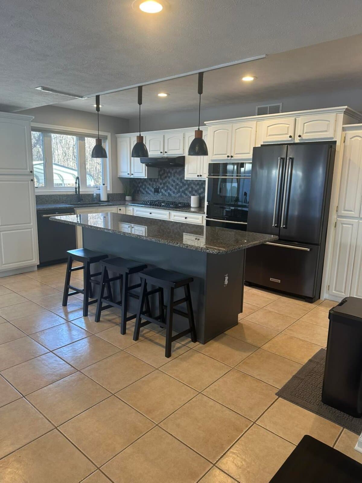 Modern white kitchen with refinished cabinets and black island