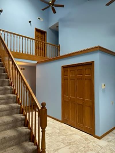 Two-story foyer painted in soft blue with white trim